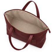 Open burgundy leather tote bag showing light lining and roomy interior from above